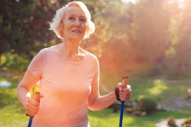 Düşünceli eski koltuk değneği elinde tutan kadın