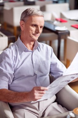 Gazete bakarak mutlu olgun adam