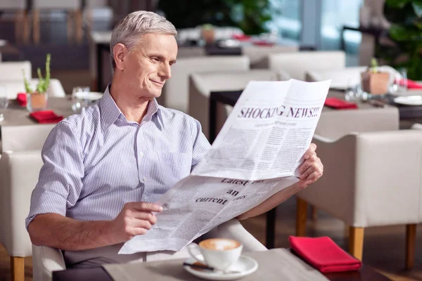 Elégedett érett ember merítik az újság olvasás — Stock Fotó