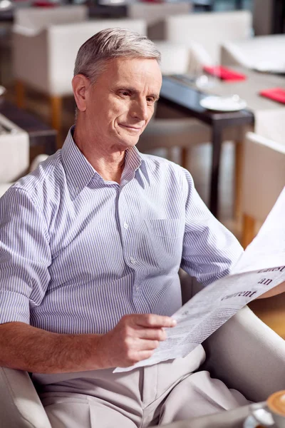 Gazete bakarak mutlu olgun adam