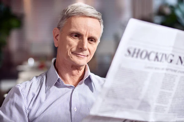 Ambitiösa mogen man inspekterar tidningen — Stockfoto