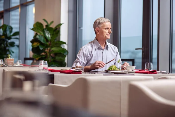 Thoughtful mature man tasting meal — Stock Photo, Image