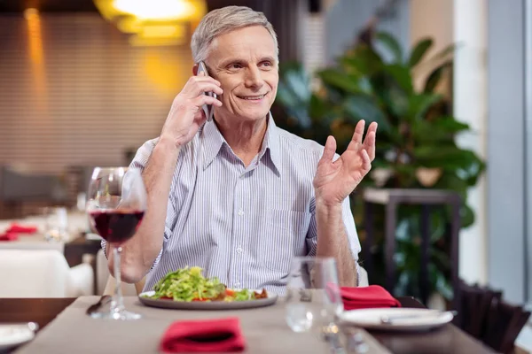 Joyful mature man picking up phone — Stock Photo, Image