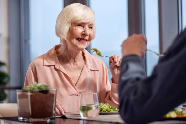 Trevlig mogen kvinna konsumerar sallad — Stockfoto