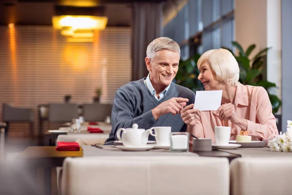 Angenehmes reifes Paar bekommt Karte — Stockfoto