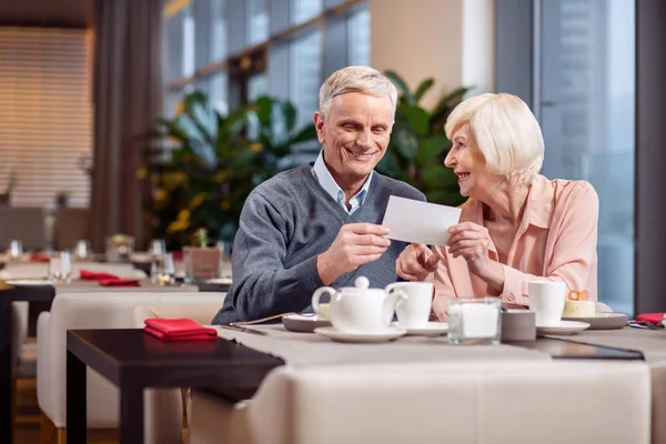 Optimistisches älteres Ehepaar erhält Karte — Stockfoto