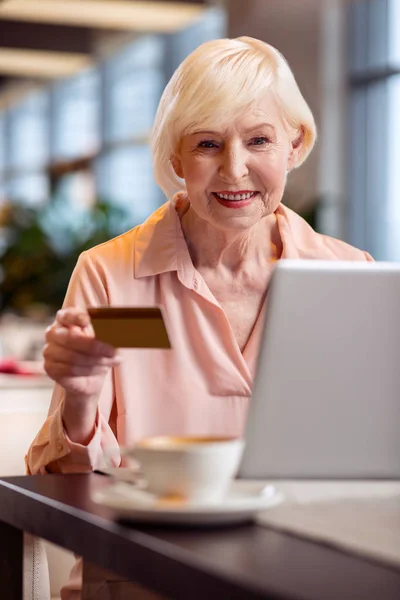 Affascinante donna matura che paga tramite Internet — Foto Stock