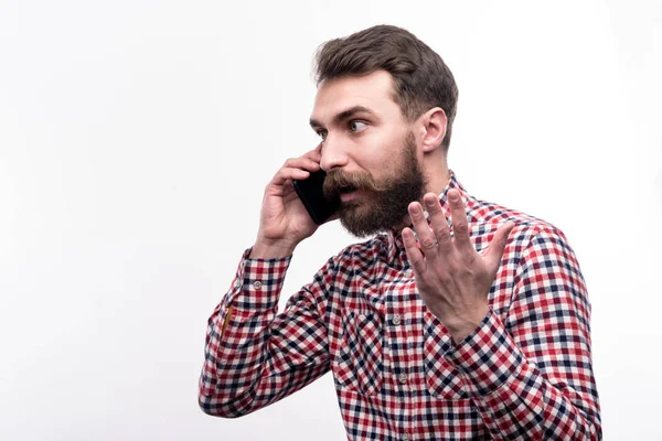 Young bearded man talking on the phone emotionally — Stock Photo, Image