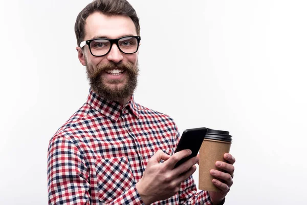 Homem alegre em óculos mensagens de texto enquanto toma café — Fotografia de Stock