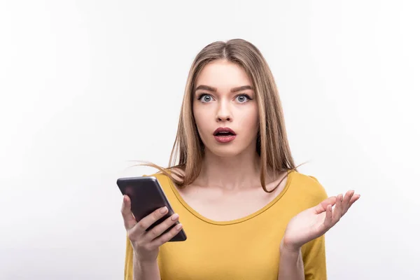 Hübsche Frau sieht überrascht aus, nachdem sie SMS gelesen hat — Stockfoto