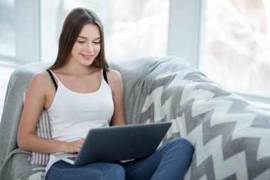 Gülümseyen kız onun bilgisayar ile rahatlatıcı