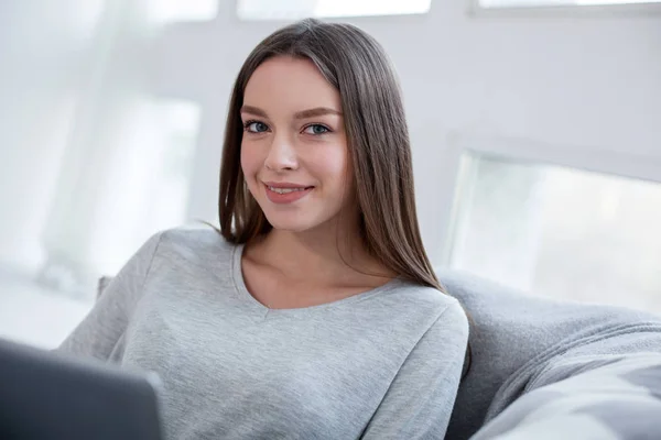 Chica alegre relajarse en casa con su ordenador portátil —  Fotos de Stock