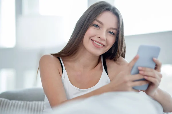 Geïnspireerd langharige vrouw met behulp van haar telefoon — Stockfoto