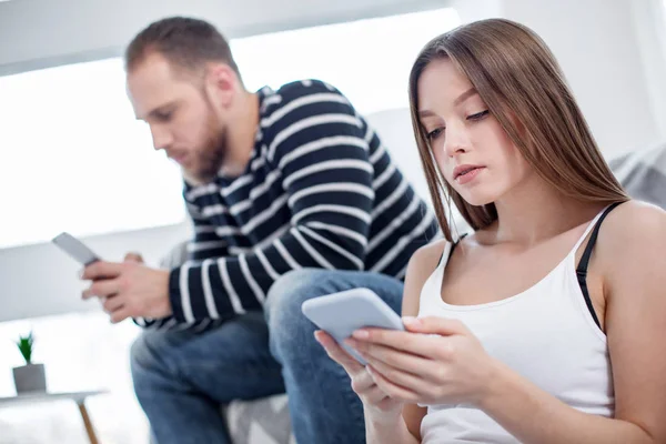 Концентрована жінка і чоловік використовують свої телефони — стокове фото