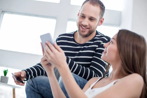 Lachende vrouw tonen van foto's aan haar man — Stockfoto