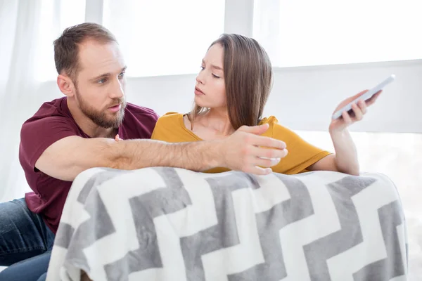 Mujer seria revisando su teléfono mans — Foto de Stock