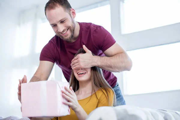 Fröhlicher Mann macht seiner geliebten Frau ein Geschenk — Stockfoto