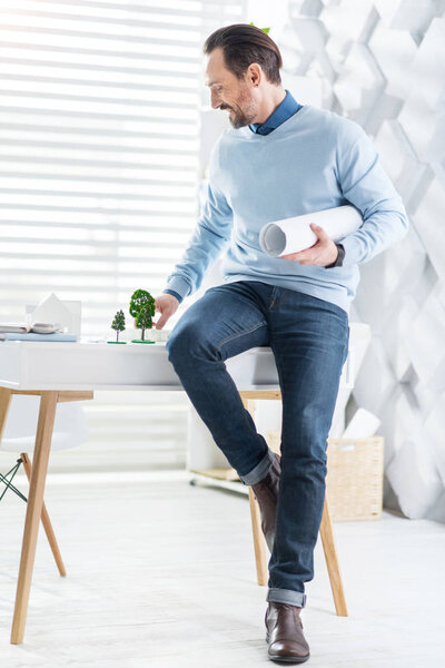 Блестящий архитектор, строящий макет дома
