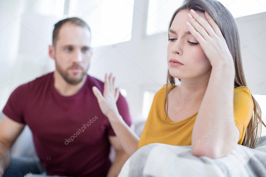 Unsmiling woman not wanting to talk with her man