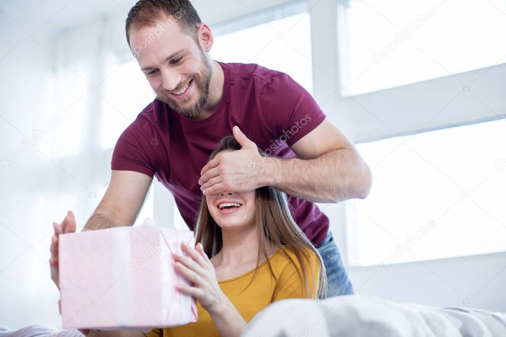 Cheerful man making a gift to his beloved woman