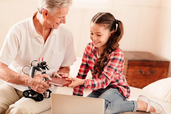 Miembros alegres de la familia experimentando con la máquina robótica —  Fotos de Stock