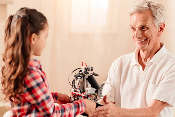 Zářící starší muž dává jeho vnučka robotické stroje — Stock fotografie
