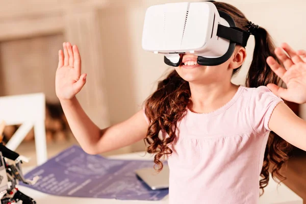 Surpreendida menina tentando em óculos de realidade virtual — Fotografia de Stock