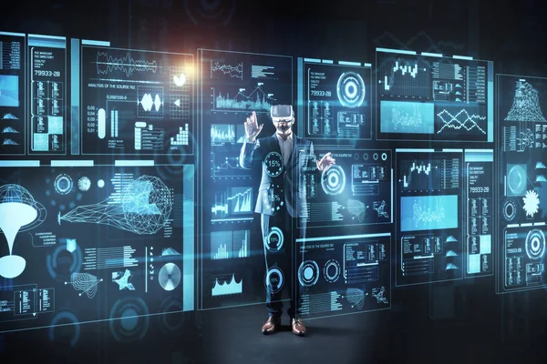 Curious programmer standing in front of a screen in virtual reality glasses — Stock Photo, Image