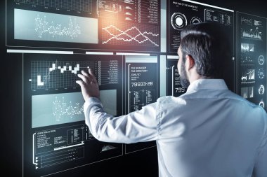 İş yerinde olurken futuristik bir ekran dokunarak sakin programcı