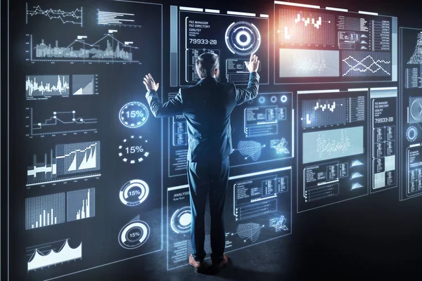 Programador elegante em pé na frente de um dispositivo gigante transparente e trabalhando — Fotografia de Stock