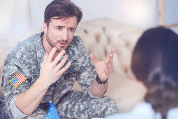 Emotional millennial soldier telling psychotherapist about years of serving