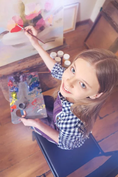 Menina de cabelos castanhos sorrindo enquanto pintava — Fotografia de Stock