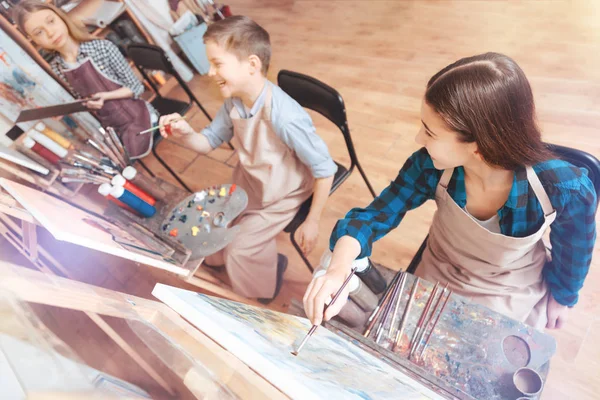 Crianças engraçadas ficando animadas enquanto pintam — Fotografia de Stock
