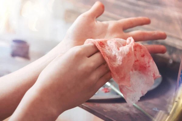 Close up of talented kid wiping hands after painting — Stock Photo, Image