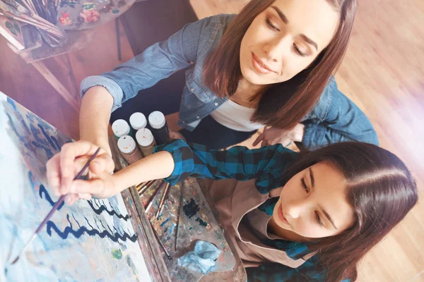 Pintor feminino ajudando menina com pintura — Fotografia de Stock