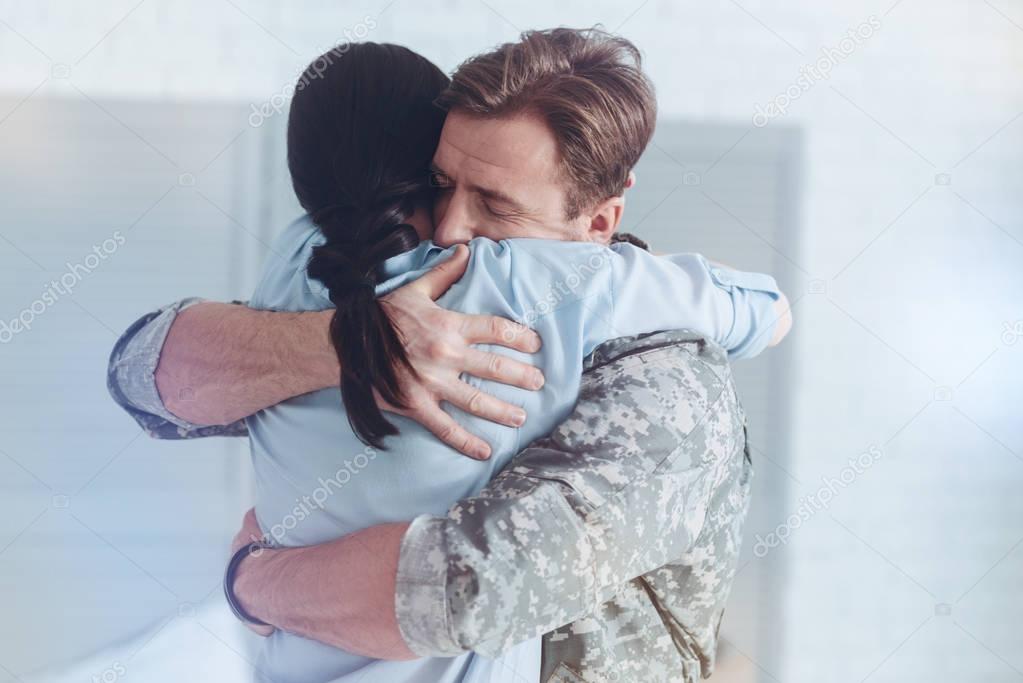 Sad woman and military husband embracing at parting