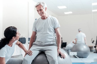 Yaşlı adam ve genç kadın birbirine bakarak gülen