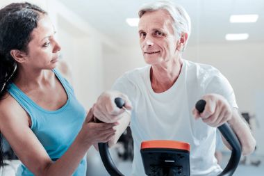 Yaşlı adam eğitim ve ona yakın ciddi bir kadın gülümseyerek