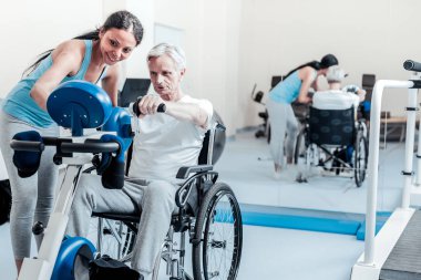 Ciddi yaşlı adam tekerlekli sandalyede otururken egzersiz