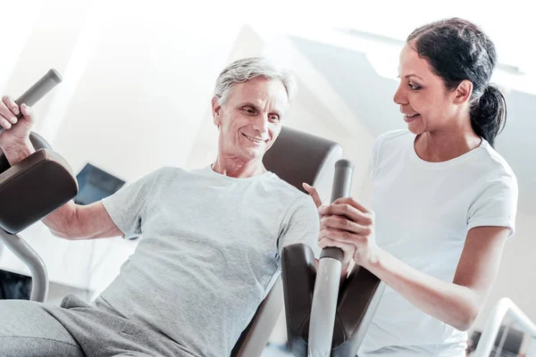 Happy trainer and a smiling old man training — Stock Photo, Image