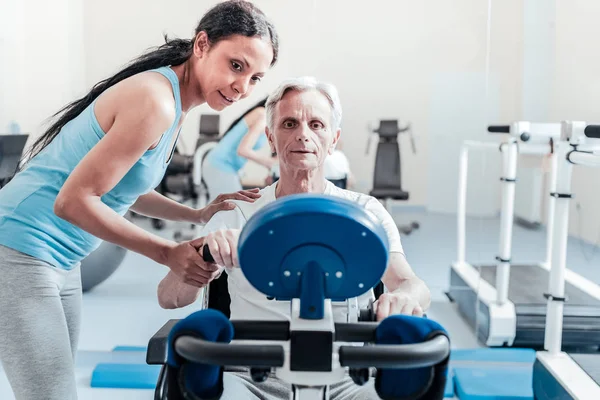 Baby-boomer concentrato che si esercita su un dispositivo di allenamento — Foto Stock