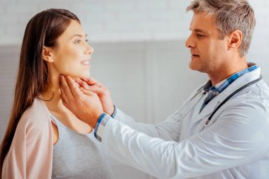 Male doctor checking lymph nodes of pregnant woman clipart