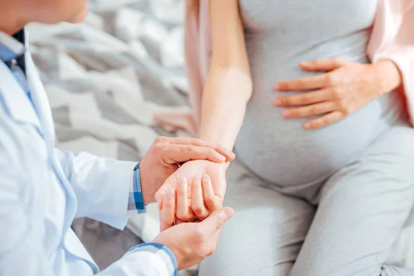 Close up of doctor measuring pulse of pregnant woman — Stock Photo, Image