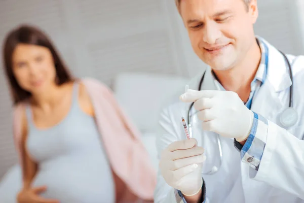 Läkare som förbereder sprutan innan du injicerar gravid kvinna — Stockfoto