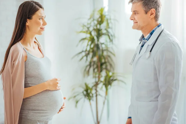 Beautiful expectant mother visiting pediatrician — Stock Photo, Image