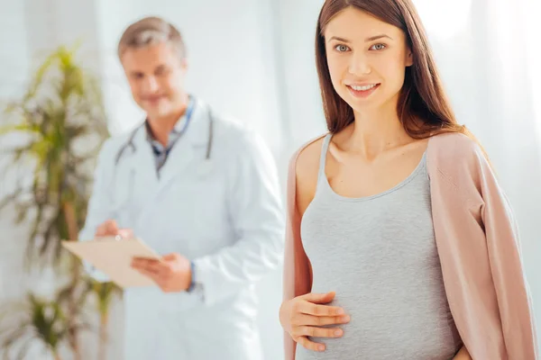 Abbastanza incinta madre sorridente in macchina fotografica — Foto Stock