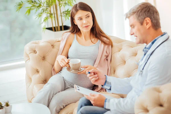 Ontspannen zwangere vrouw luisteren naar dokter tijdens afspraak — Stockfoto