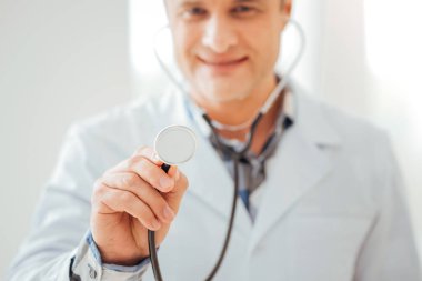 Ayakta ve onun statoscope holding neşeli yetenekli doktor.