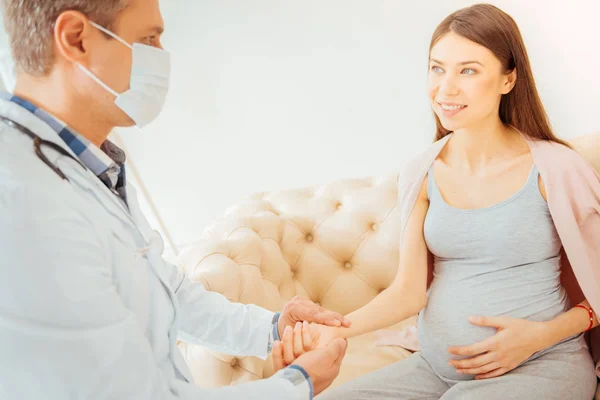 Beautiful pregnant woman checking pulse at doctor — Stock Photo, Image