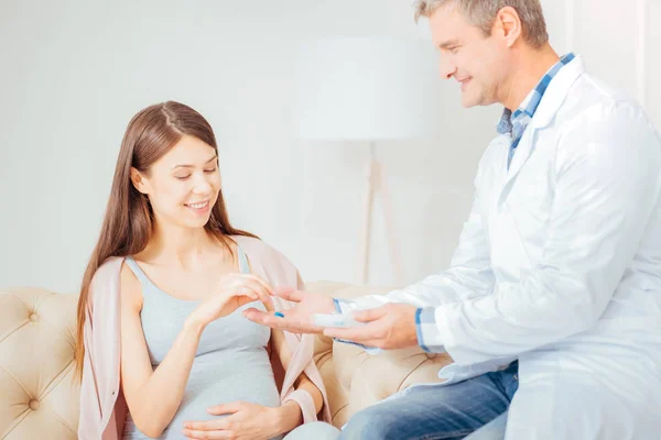 Mujer joven agradable sentado y tomando una píldora . — Foto de Stock